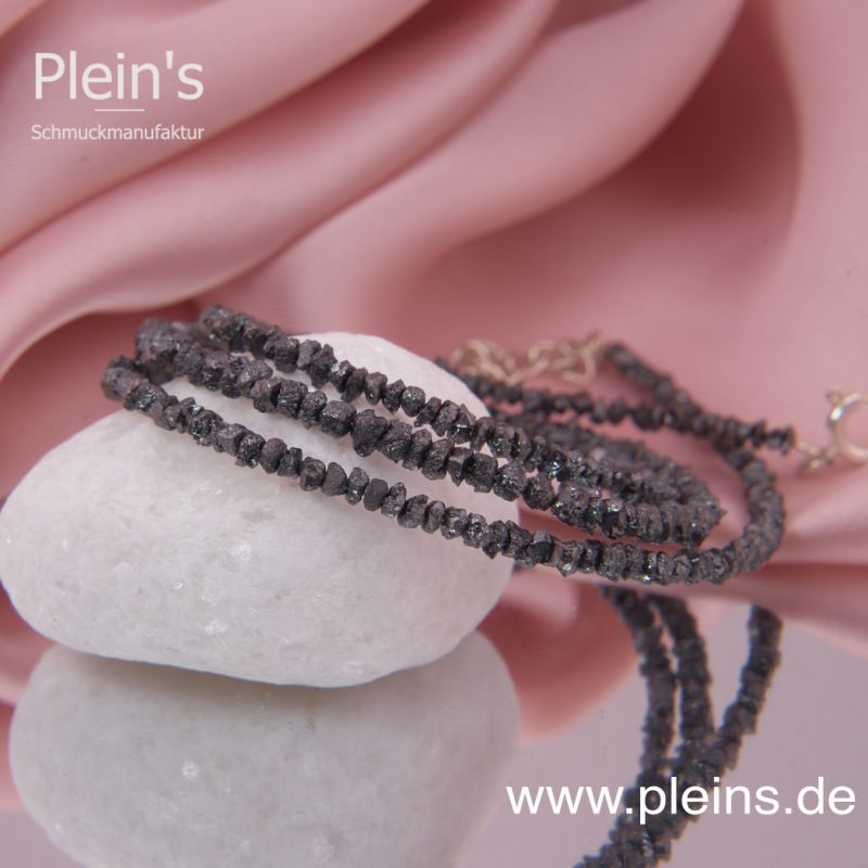 Preview: Nahaufnahme einer schwarzen Rohdiamantkette mit fein beleuchteten, schimmernden Splittern.
